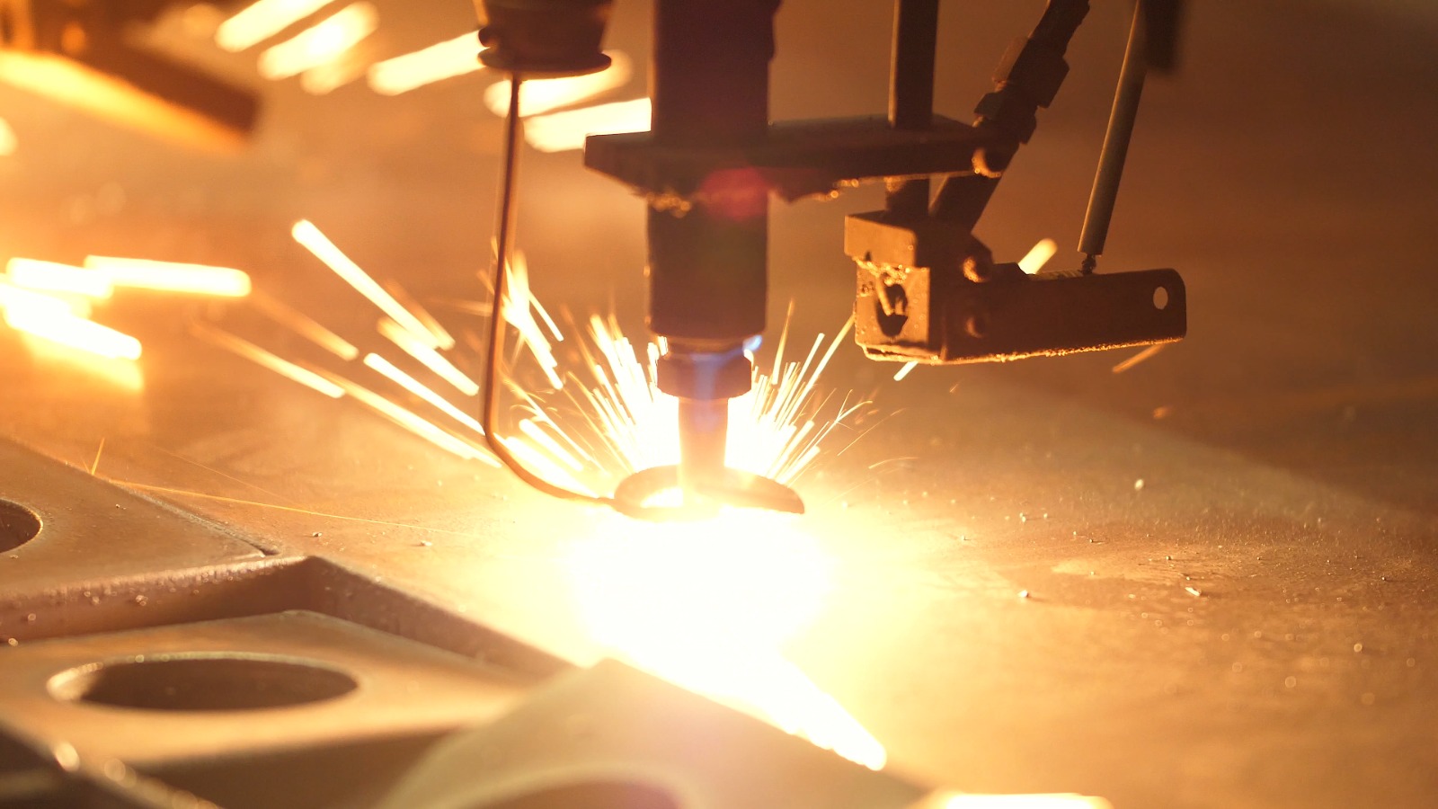 Thick steel plate being cut with sparks on a CNC oxygen cutting table